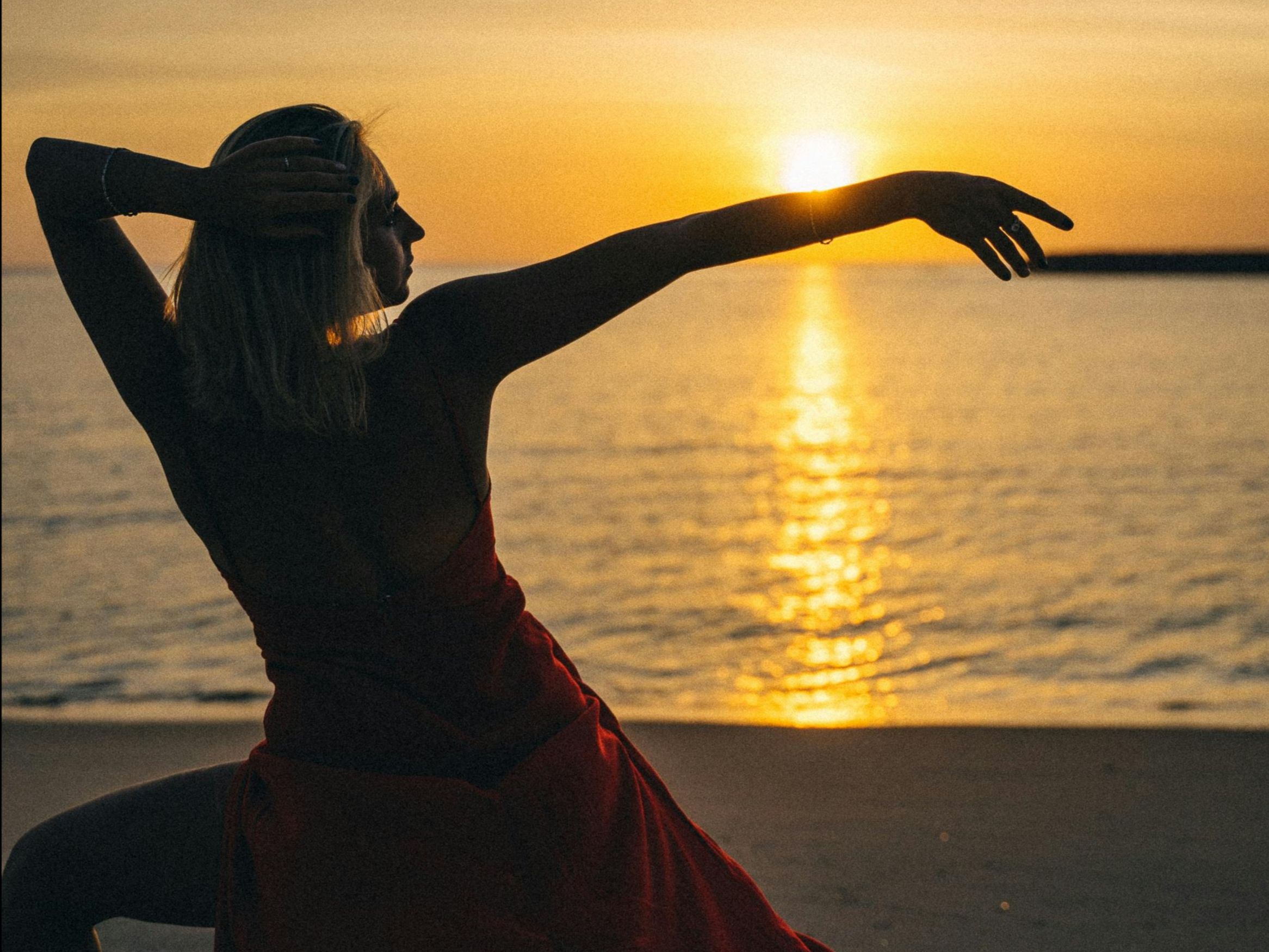 Women dancing together at sunset on the beach